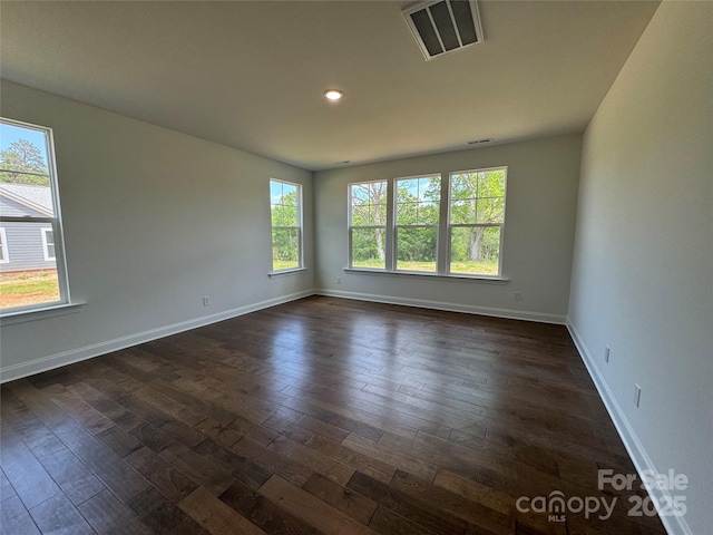 spare room with dark wood-style floors, baseboards, visible vents, and recessed lighting