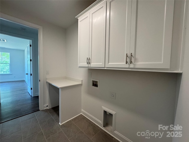 washroom featuring visible vents, baseboards, washer hookup, cabinet space, and dark tile patterned floors