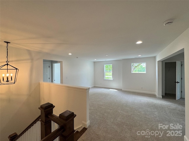 interior space featuring dark colored carpet, baseboards, recessed lighting, and a chandelier