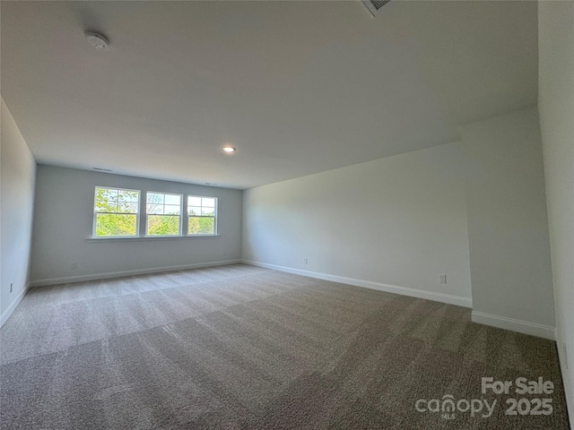 spare room featuring recessed lighting, carpet floors, and baseboards