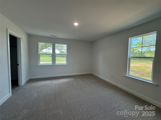 carpeted spare room with baseboards and visible vents
