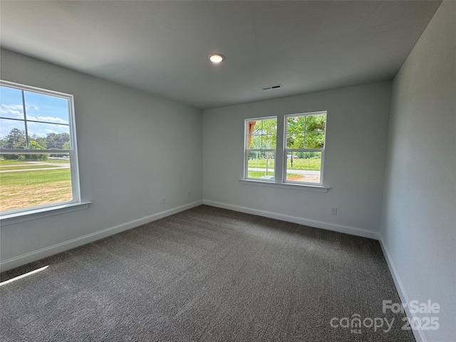 carpeted empty room featuring baseboards, visible vents, and recessed lighting