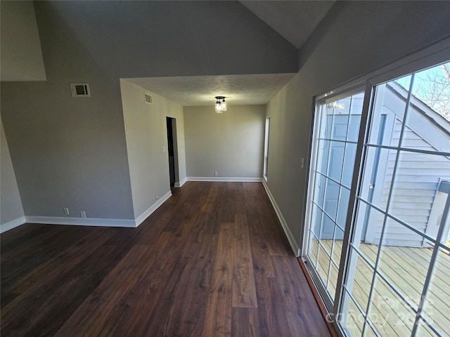 hall with vaulted ceiling and dark hardwood / wood-style flooring