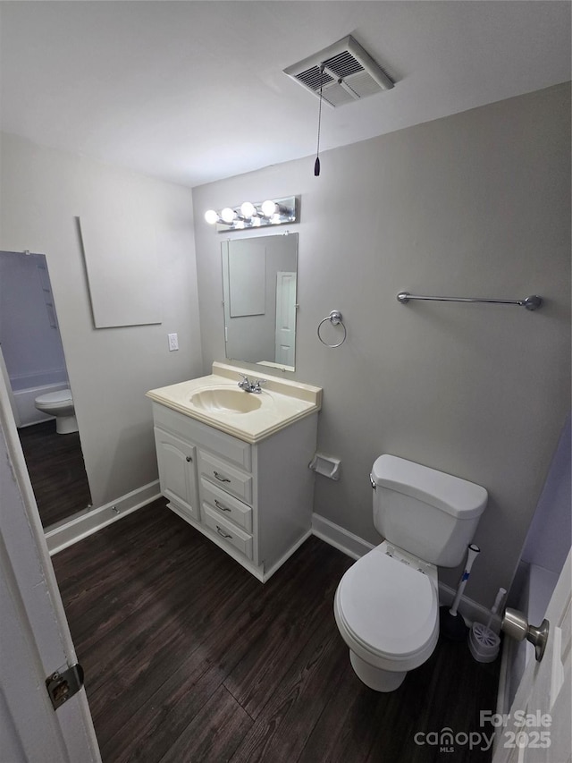 bathroom featuring vanity, wood-type flooring, and toilet