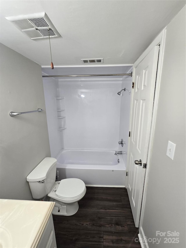 full bathroom with vanity, hardwood / wood-style floors, toilet, and washtub / shower combination