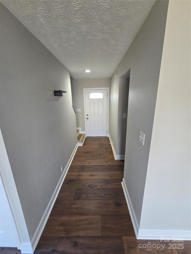 doorway to outside featuring dark hardwood / wood-style flooring and a textured ceiling