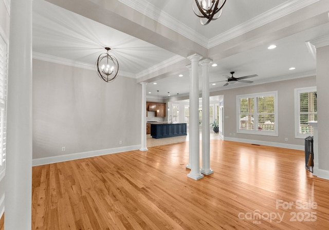 unfurnished living room featuring ornate columns, ceiling fan with notable chandelier, sink, ornamental molding, and light hardwood / wood-style floors