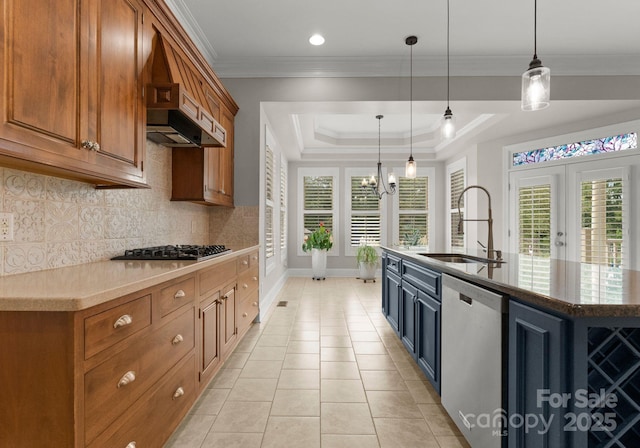 kitchen with pendant lighting, appliances with stainless steel finishes, sink, and an island with sink