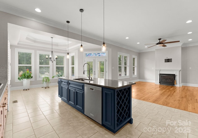 kitchen with blue cabinetry, dishwasher, a center island with sink, decorative light fixtures, and light tile patterned flooring