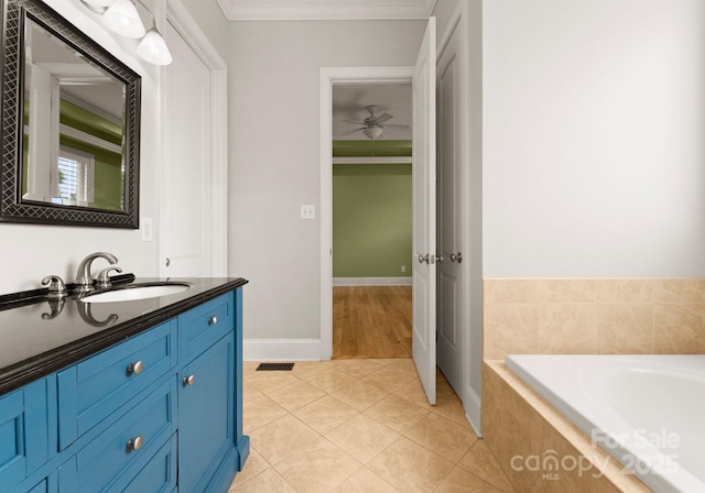 bathroom featuring tiled tub, ornamental molding, tile patterned floors, and vanity