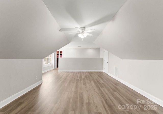 bonus room with lofted ceiling, light wood-type flooring, and ceiling fan