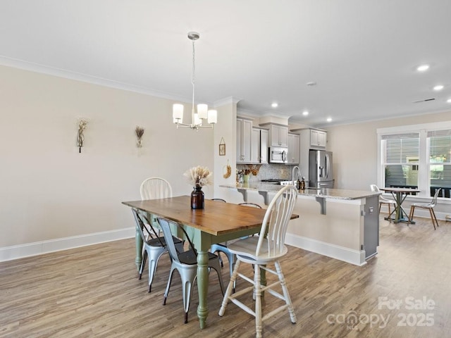 dining room featuring an inviting chandelier, crown molding, and light hardwood / wood-style floors