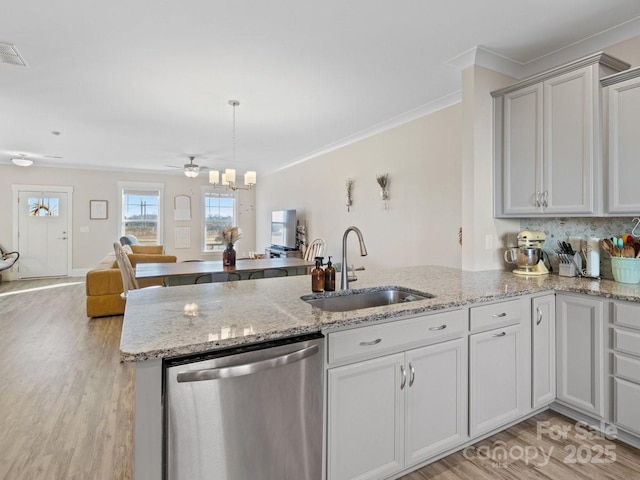 kitchen with stainless steel dishwasher, light hardwood / wood-style floors, sink, and kitchen peninsula