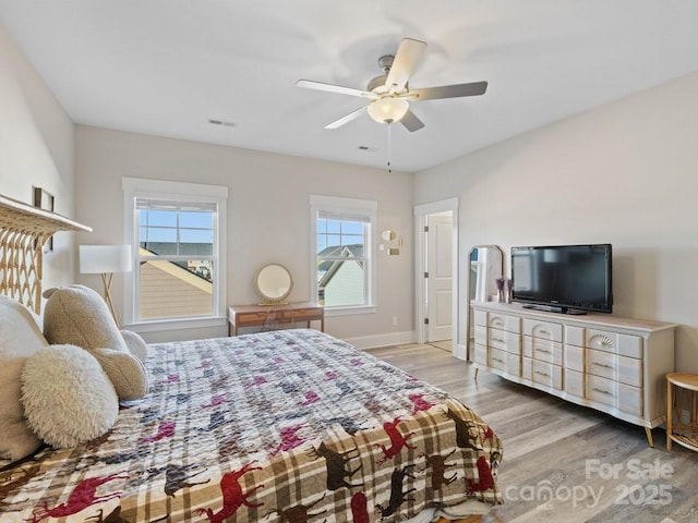 bedroom with multiple windows, ceiling fan, and light wood-type flooring