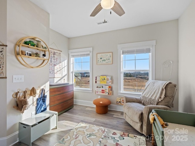 sitting room featuring ceiling fan and light wood-type flooring