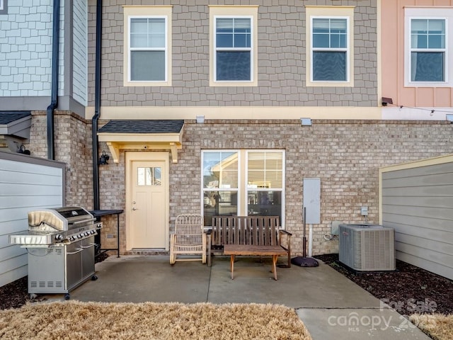 rear view of property featuring a patio area and central air condition unit