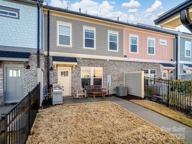 rear view of property with cooling unit and a patio