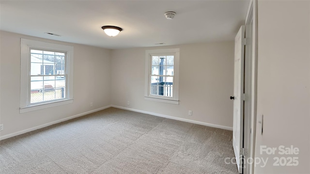 empty room with carpet floors and a healthy amount of sunlight