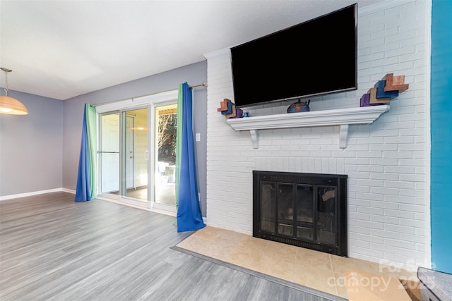 unfurnished living room with a brick fireplace and wood-type flooring