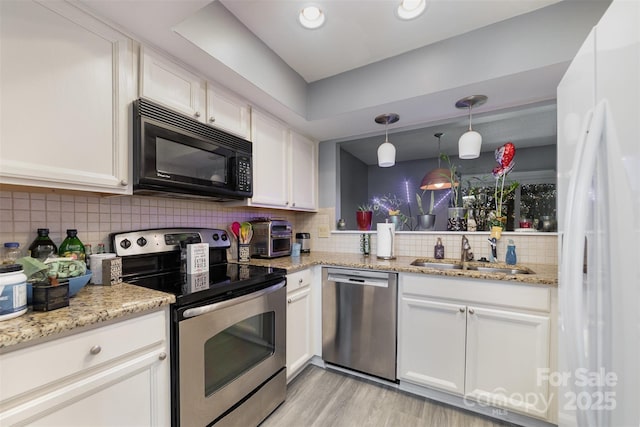 kitchen featuring sink, white cabinetry, decorative light fixtures, stainless steel appliances, and backsplash