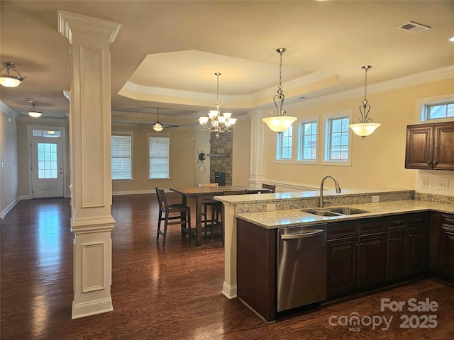 kitchen featuring stainless steel dishwasher, decorative light fixtures, and ornate columns