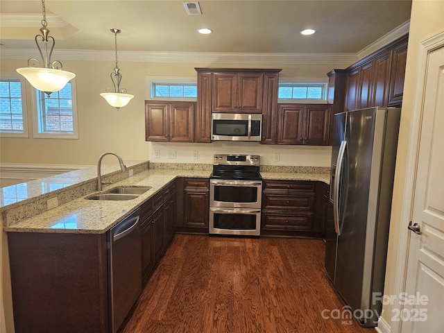 kitchen featuring pendant lighting, sink, light stone counters, kitchen peninsula, and stainless steel appliances