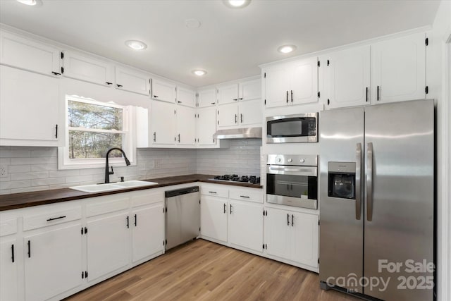 kitchen featuring white cabinetry, sink, light hardwood / wood-style flooring, and stainless steel appliances