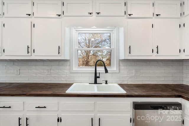 kitchen featuring dishwasher, sink, white cabinets, and backsplash