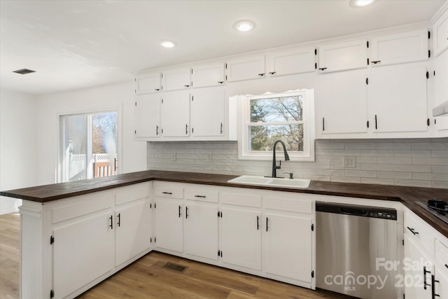 kitchen with white cabinetry, sink, backsplash, stainless steel dishwasher, and light hardwood / wood-style flooring