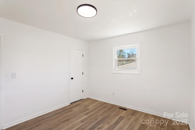 empty room with hardwood / wood-style flooring