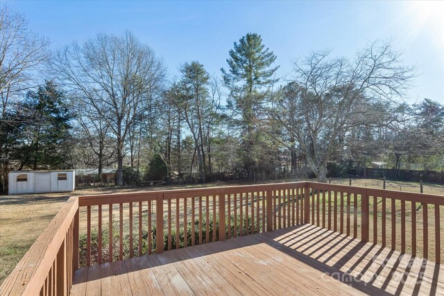 wooden deck with a storage shed and a yard