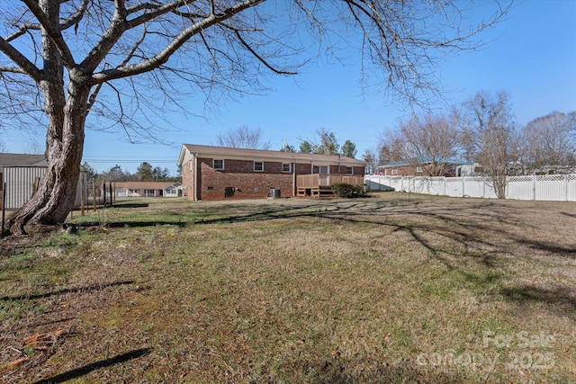 back of property featuring a wooden deck and a lawn