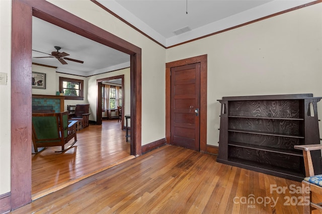 entryway featuring crown molding, hardwood / wood-style floors, and ceiling fan