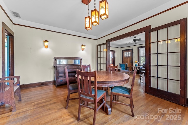 dining room featuring ornamental molding, a chandelier, hardwood / wood-style floors, and a fireplace