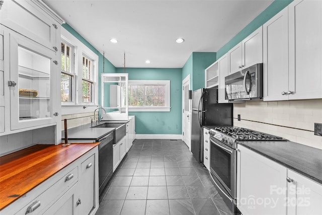 kitchen featuring white cabinetry, sink, decorative backsplash, and black appliances