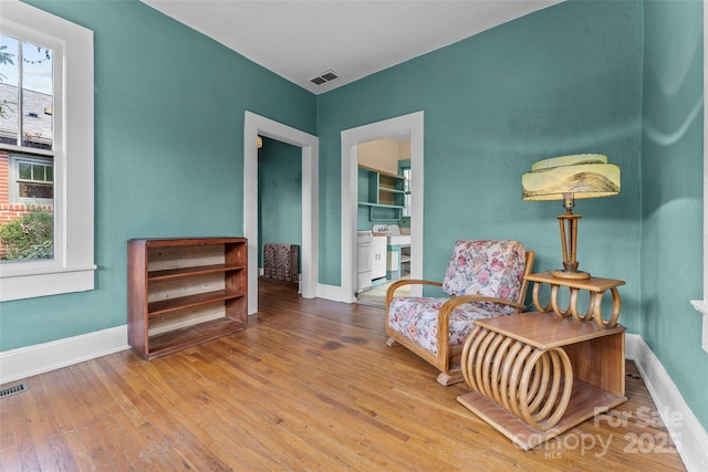 sitting room with plenty of natural light and wood-type flooring