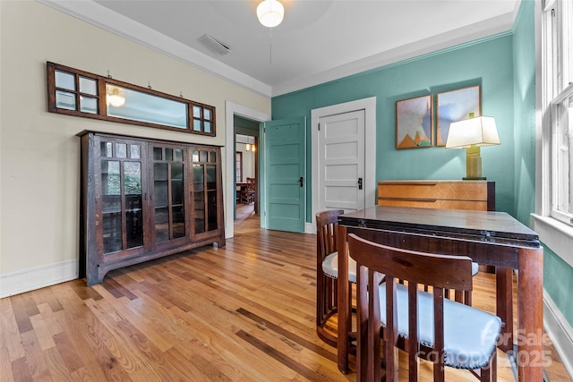 interior space with ornamental molding, a wealth of natural light, and light wood-type flooring