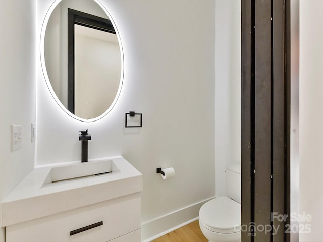 bathroom with vanity, hardwood / wood-style floors, and toilet