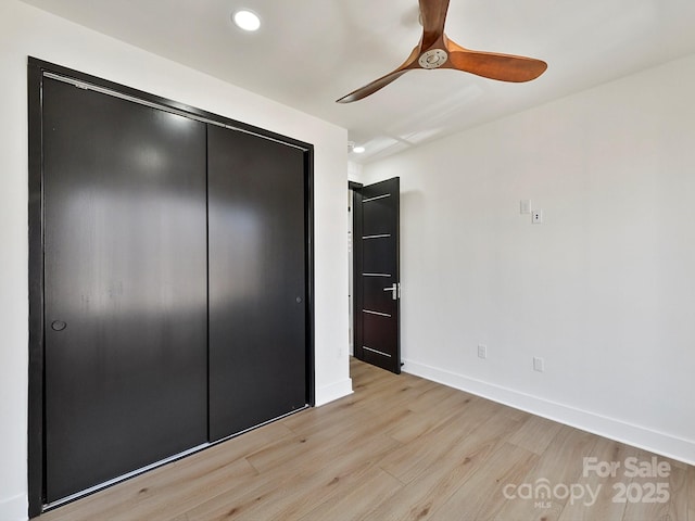 unfurnished bedroom with ceiling fan, light hardwood / wood-style floors, and a closet