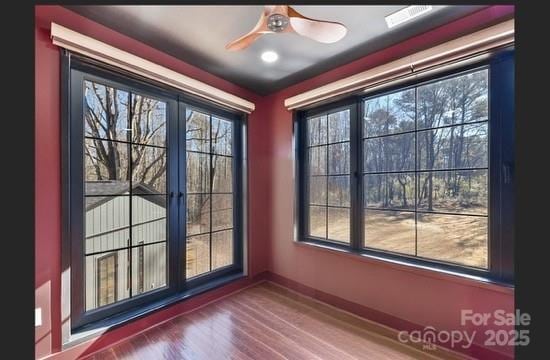 doorway with wood-type flooring and ceiling fan