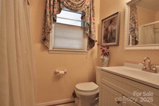 bathroom featuring vanity, crown molding, and toilet