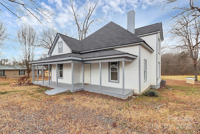 back of property featuring a porch, central AC, and a chimney