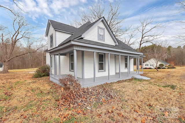 view of home's exterior featuring covered porch and a yard