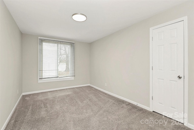 unfurnished room featuring carpet flooring and baseboards