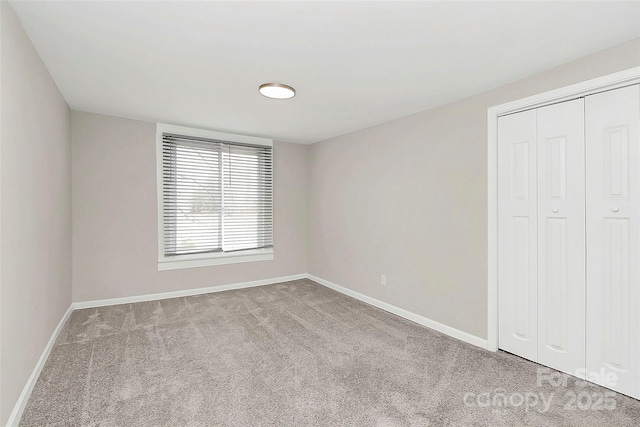 unfurnished bedroom with a closet, baseboards, and carpet