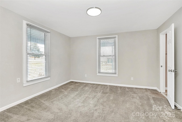 carpeted spare room featuring baseboards