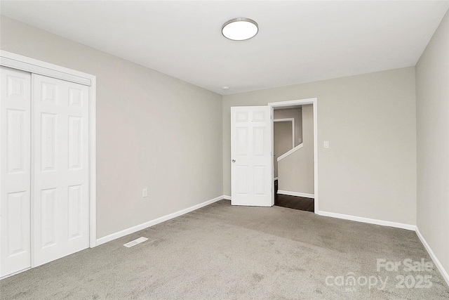 unfurnished bedroom with visible vents, carpet, baseboards, and a closet