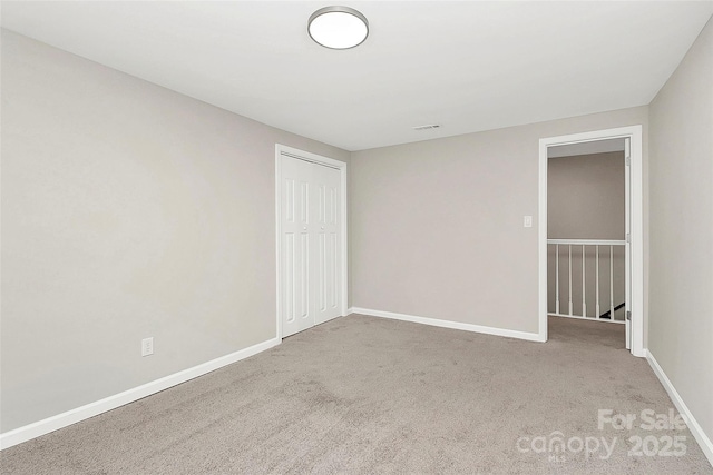 empty room featuring visible vents, baseboards, and carpet flooring