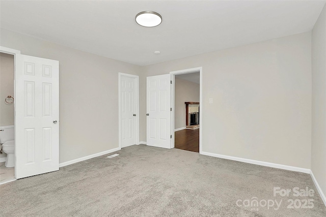 unfurnished bedroom featuring a fireplace, baseboards, and carpet floors