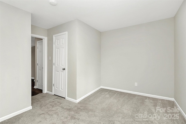 empty room featuring baseboards and carpet floors